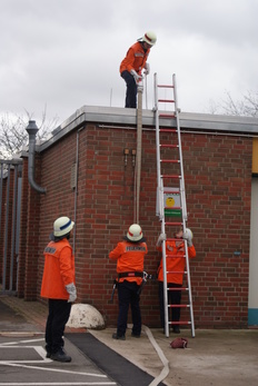 Feuerwehrübung mit Gefangenen die eine Leiter hochklettern