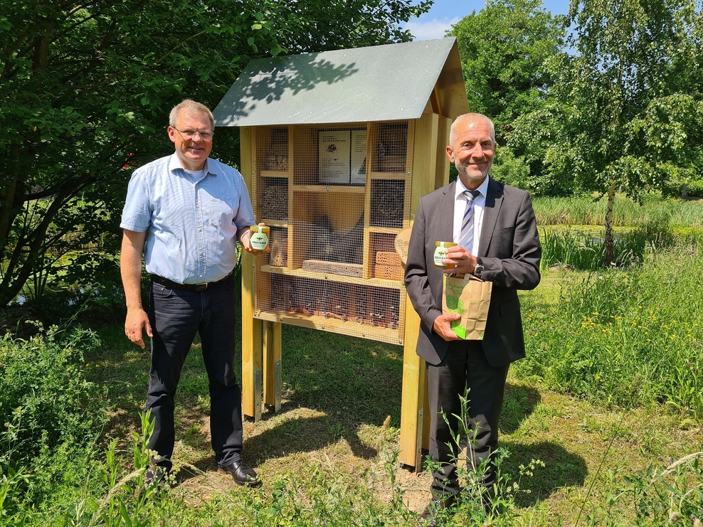 Vor einem Insektenhotel sind Landrat Adomat und Anstaltsleiter Kuhlmann zu sehen