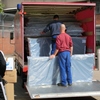 Gefangene laden Hilfsgüter auf einen Transporter